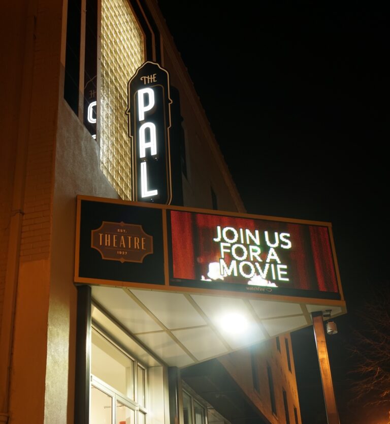 The outside of The PAL theatre. The PAL sign reads join us for a movie.